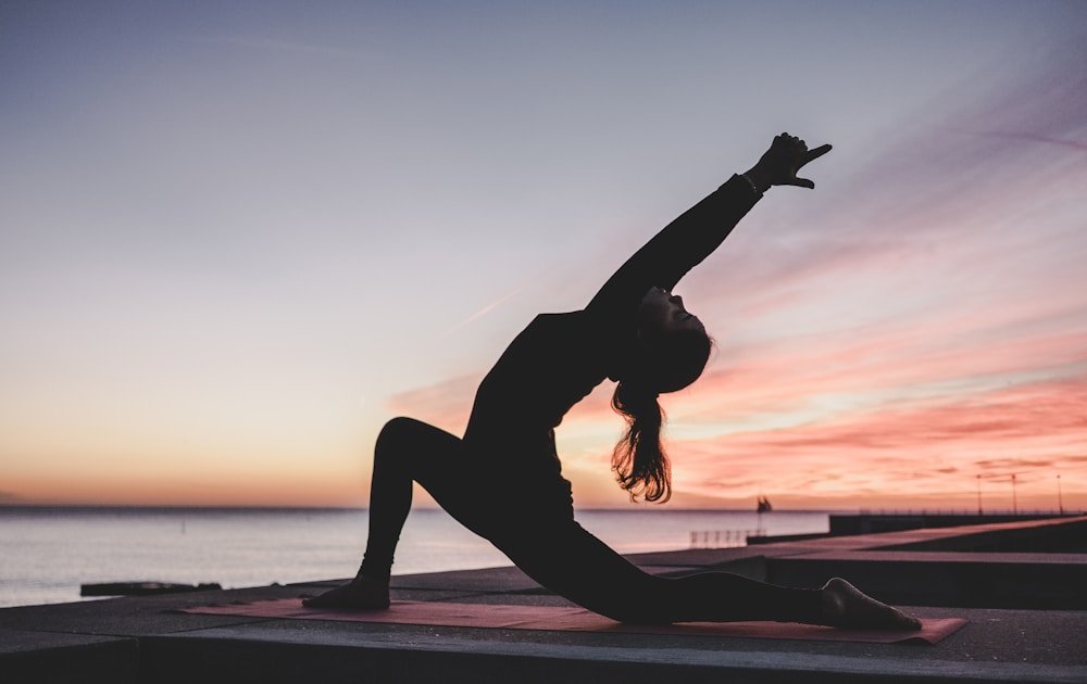 A person stretching outdoors at sunset