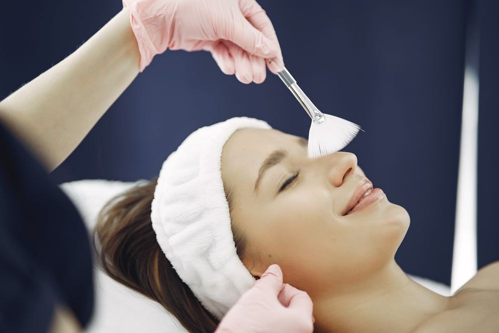 A woman receiving a gentle professional facial treatment