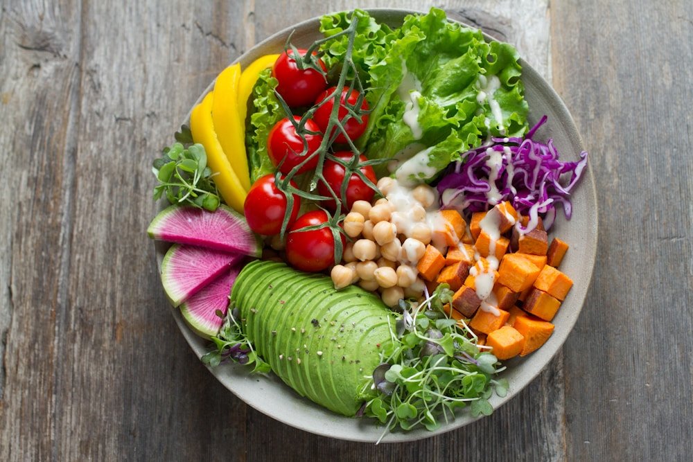 A colorful bowl of vegetables, chickpeas, and avocado